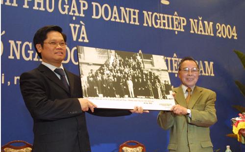 Nguyên Thủ tướng Phan Văn Khải tặng Chủ tịch VCCI Vũ Tiến Lộc bức tranh Bác Hồ với giới công thương Hà Nội nhân dịp công bố "Ngày Doanh nhân Việt Nam" năm 2004.<br>