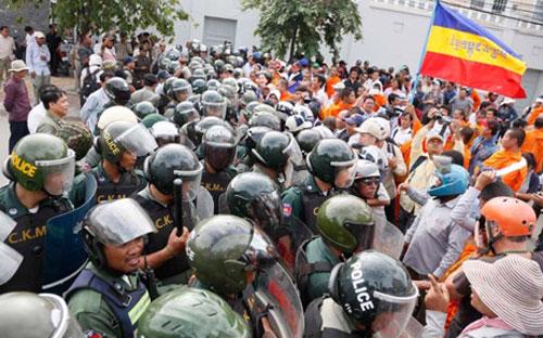 Cảnh sát Campuchia chặn nhóm gây rối trước Đại sứ quán Việt Nam - Ảnh: The Phnom Penh Post.<br>