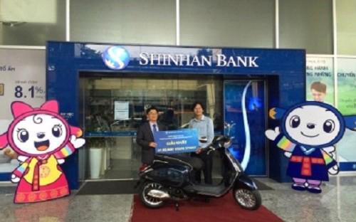 Ông Heo Young Taeg Tổng Giám đốc Ngân hàng Shinhan Việt Nam giải thưởng xe máy Vespa cho anh Ngô Hoàng Việt Dũng.