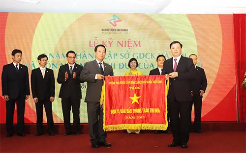 Chủ tịch Hội đồng Quản trị kiêm Tổng giám đốc HNX Trần Văn Dũng đón nhận cờ thi đua do Bộ trưởng Tài Chính Đinh Tiến Dũng trao.