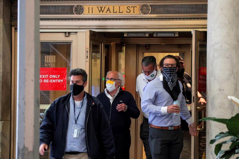 Các nhà giao dịch cổ phiếu xuất hiện ở cửa Sở Giao dịch chứng khoán New York (NYSE) tại số 11 Wall Street hôm 26/6/2020 - Ảnh: Reuters.