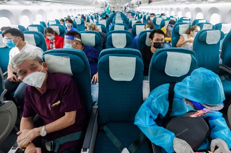 Hành khách trên chuyến bay của Vietnam Airlines thực hiện ngồi giãn cách ghế theo đúng quy định.