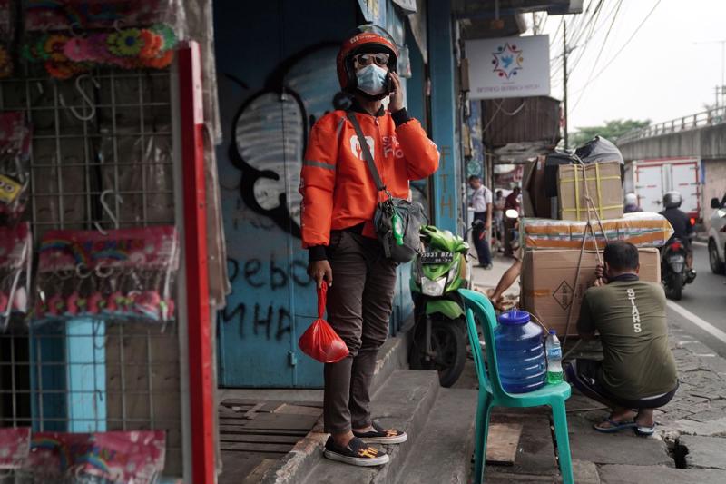 Một nhân viên Shopee giao hàng thực phẩm ở Jakarta, Indonesia - Ảnh: Bloomberg.