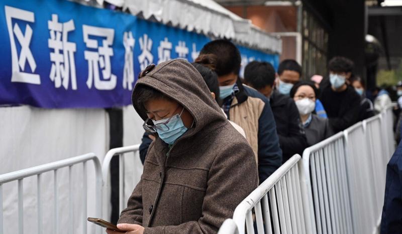 Người dân tại Bắc Kinh xếp hàng chờ tiêm mũi tăng cường - Ảnh: Reuters
