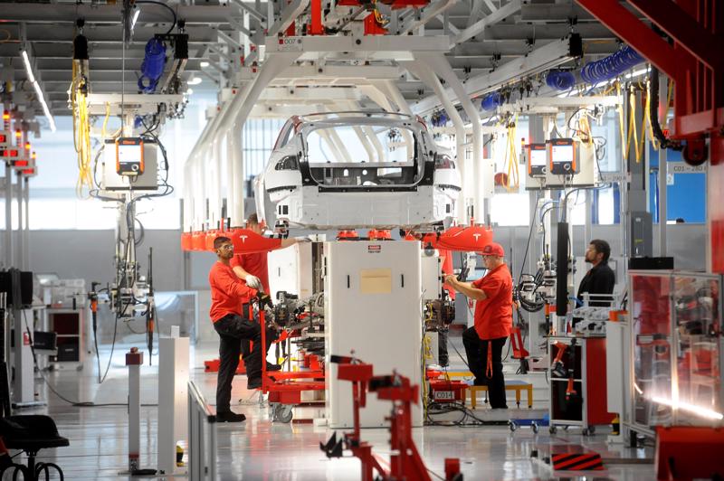 Lắp ráp ô tô điện trong một nhà máy của Tesla ở Mỹ - Ảnh: Reuters.