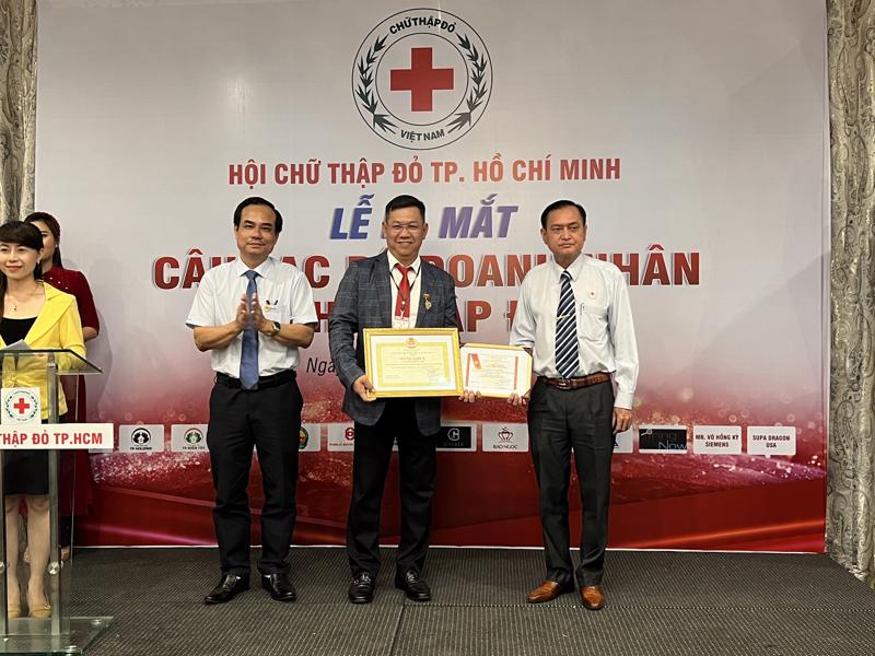 Ông Nguyễn Hoàng Hiệp (đứng giữa) nhận quyết định thành lập Câu lạc bộ Doanh nhân Chữ thập đỏ TP.HCM và quyết định Chủ nhiệm Câu lạc bộ từ ông Trần Trường Sơn, Chủ tịch Hội Chữ thập đỏ TP.HCM (ngoài cùng bên phải) ngày 21/1/2022.