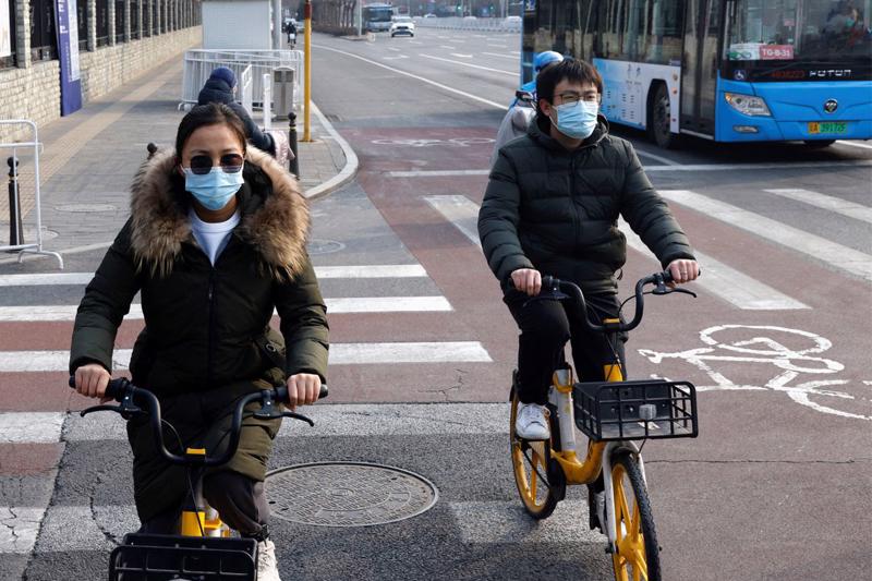 Người dân đạp xe trên đường phố ở Bắc Kinh, Trung Quốc hôm 22/1 - Ảnh: Reuters.