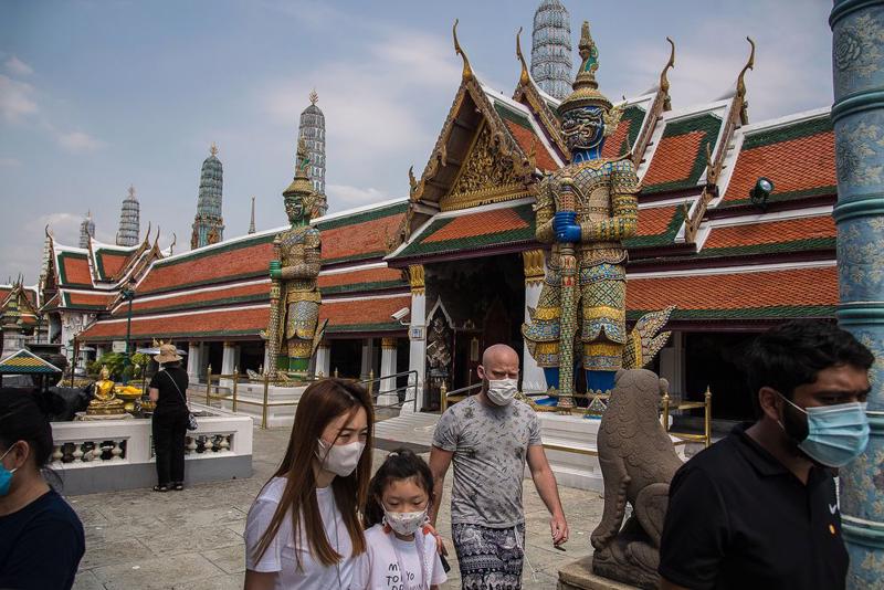 Du khách đeo khẩu trang khi tham quan chùa Phật Ngọc ở Bangkok, Thái Lan - Ảnh: Getty Images