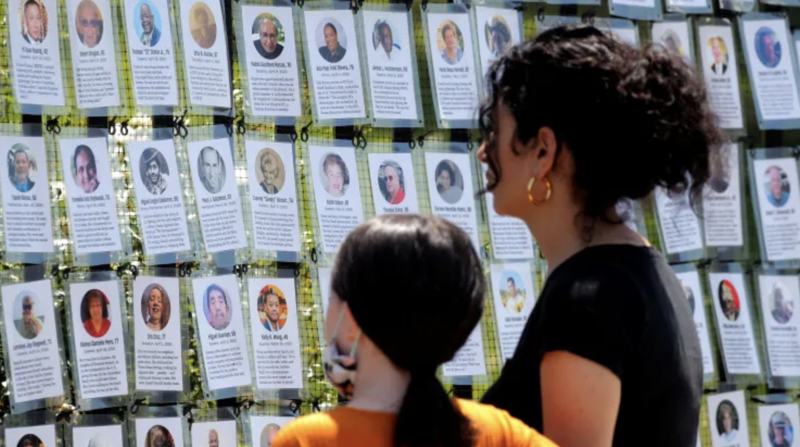 Một phụ nữ và một bé gái đứng trước khu vực tưởng niệm những người tử vong vì Covid-19 ở Brooklyn, New York, Mỹ, tháng 6/2021 - Ảnh: Reuters.