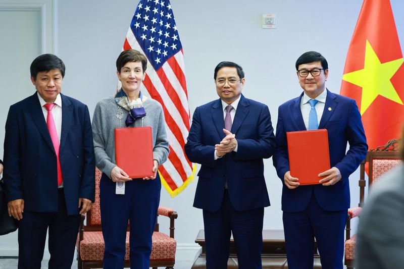 Bà Stephanie von Friedeburg - Phó chủ tịch điều hành cao cấp IFC (thứ hai từ trái sang) và ông Trần Hoài Nam - Phó Tổng giám đốc HDBank (bìa phải) trao văn kiện ký kết dưới sự chứng kiến của Thủ tướng Chính phủ Phạm Minh Chính.