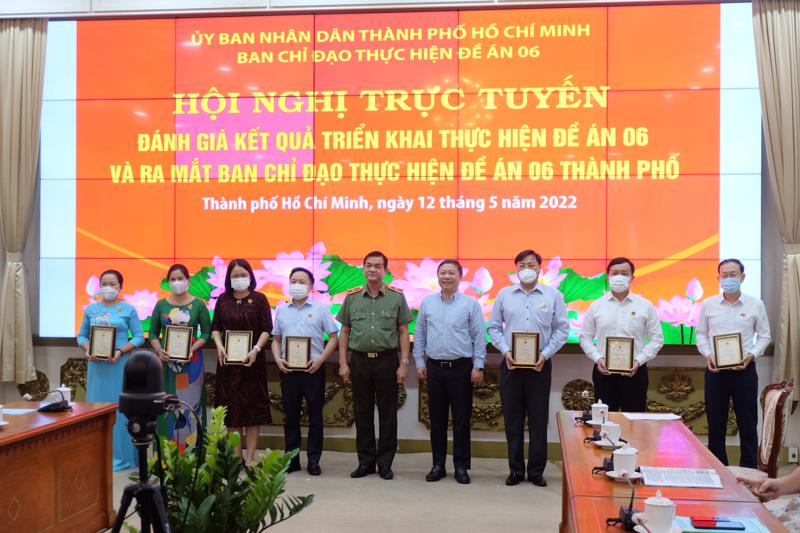 Thiếu tướng Lê Hồng Nam và Phó Chủ tịch UBND TP.HCM Dương Anh Đức trao tặng kỷ niệm chương “Vì sự nghiệp xây dựng cơ sở dữ liệu quốc gia về dân cư” cho các cá nhân xuất sắc chiều 12/5. 