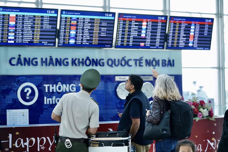 Một nhân viên an ninh hỗ trợ hướng dẫn hành khách tại Cảng hàng không quốc tế Nội Bài.