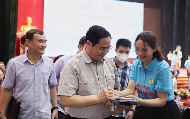 Prime Minister Pham Minh Chinh (C) speaking with workers (Photo by Hải Nguyễn)