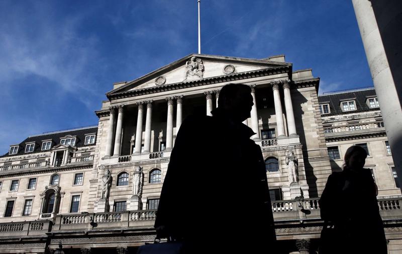 Người bộ hành đi qua trụ sở Ngân hàng Trung ương Anh (BOE) ở London, tháng 3/2015 - Ảnh: Reuters.