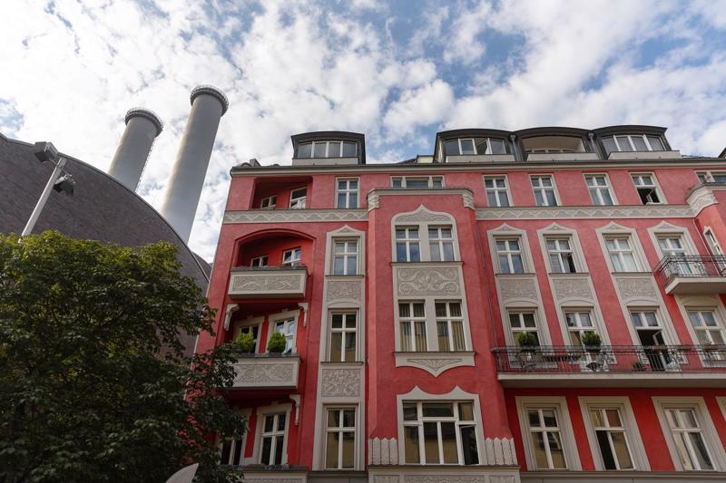 Ống khói của một nhà máy cung cấp nhiệt sưởi nằm sau một toà nhà chung cư ở Berline, Đức hôm 9/8/2022 - Ảnh: Bloomberg.