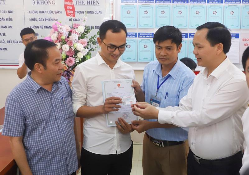 Phó Tổng Giám đốc Bảo hiểm xã hội Việt Nam Chu Mạnh Sinh trao thẻ bảo hiểm y tế của bé Đinh Bảo N cho anh Đinh Văn Hoàng. 