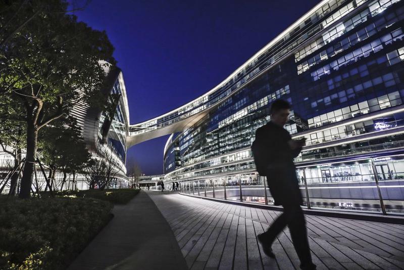 Một người đi bộ đi ngang qua tòa nhà Sky Soho ở Thượng Hải, Trung Quốc - Ảnh: Bloomberg