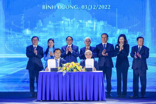 Prime Minister Pham Minh Chinh (standing, 3rd from left) witnesses the signing of a cooperation agreement for the development of an innovation ecosystem and support for industrial digitization.