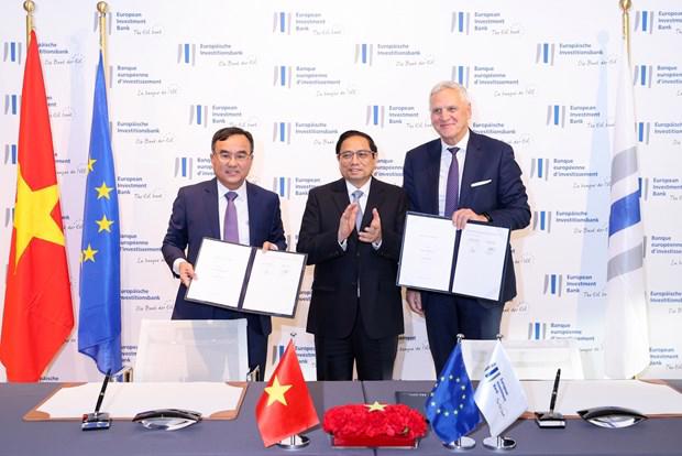 Prime Minister Pham Minh Chinh (center) witnessing the signing of an MoU between EVN and the EIB in Luxembourg on December 10. Photo: VNA