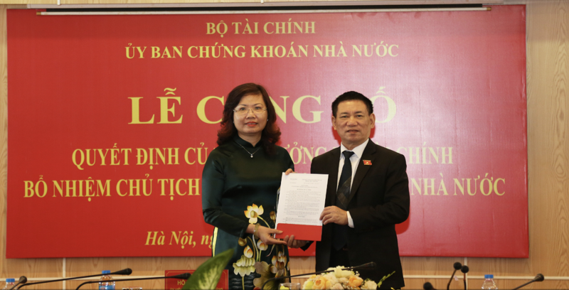 Bộ trưởng Bộ Tài chính Hồ Đức Phớc (bên trái)  trao quyết định bổ nhiệm Chủ tịch Ủy ban Chứng khoán Nhà nước đối với bà Vũ Thị Chân Phương. 