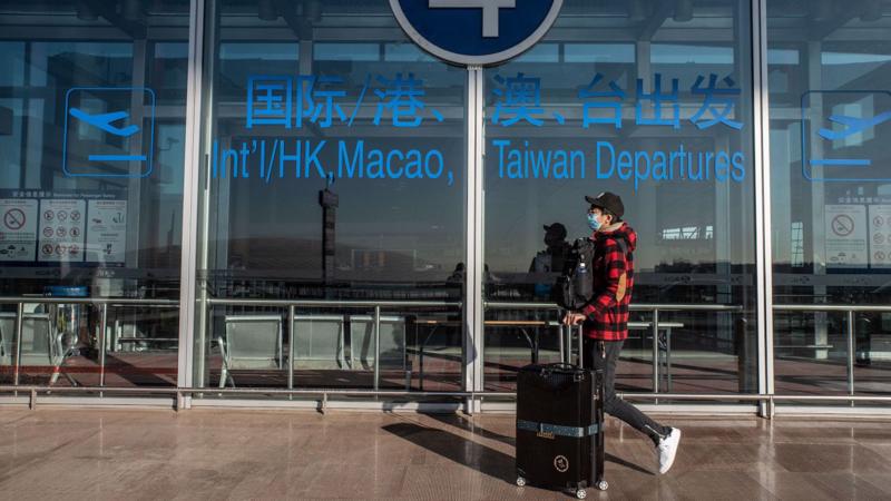 Một hành khách ở sân bay quốc tế Bắc Kinh hôm 30/12 - Ảnh: Bloomberg.