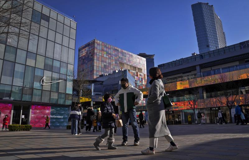 Người đi bộ ở Bắc Kinh vào ngày 4/12 khi các cửa hàng đã mở cửa trở lại - Ảnh: AP