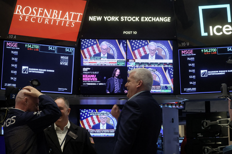 Các nhà giao dịch chứng khoán Mỹ theo dõi thông tin về cuộc họp của Fed qua màn hình trên sàn NYSE ngày 22/3 - Ảnh: Reuters.
