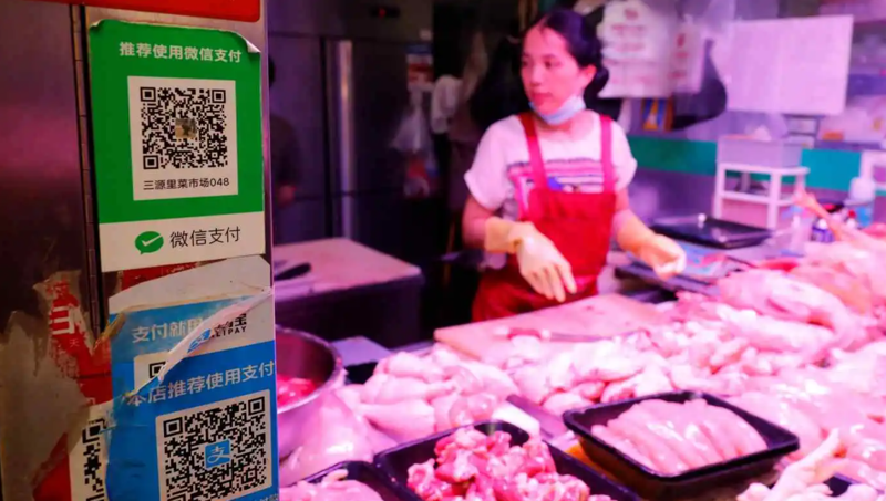 Một quầy thịt ở Bắc Kinh chấp nhận thanh toán không tiền mặt qua việc mã QR. Trung Quốc là quốc gia ít phụ thuộc vào tiền mặt nhất ở châu Á trong năm 2022 - Ảnh: Reuters