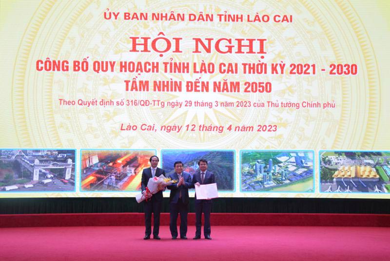 Minister of Planning and Investment Nguyen Chi Dung hands over the decision approving Lao Cai province’s master planning to the provincial leader at a ceremony on April 12.