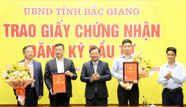 Authorities in Bac Giang province present investment licenses to the two projects.