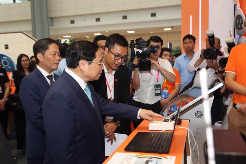 Prime Minister Pham Minh Chinh and Head of the Party Central Committee’s Commission for Economic Affairs Tran Tuan Anh visit the expo held on the sidelines of the Industry 4.0 Summit.