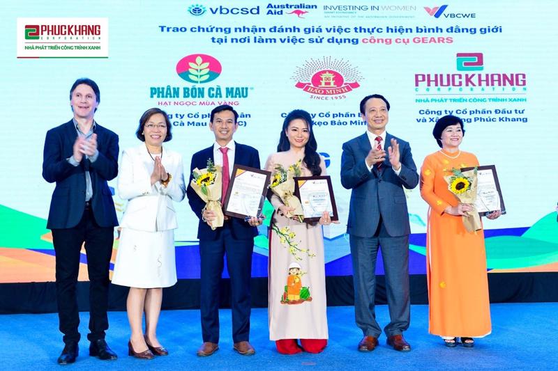 A representative from the Phuc Khang Corporation (dressed in an ao dai) receives the GEARS certificate for the company’s implementation of gender equality in the workplace.