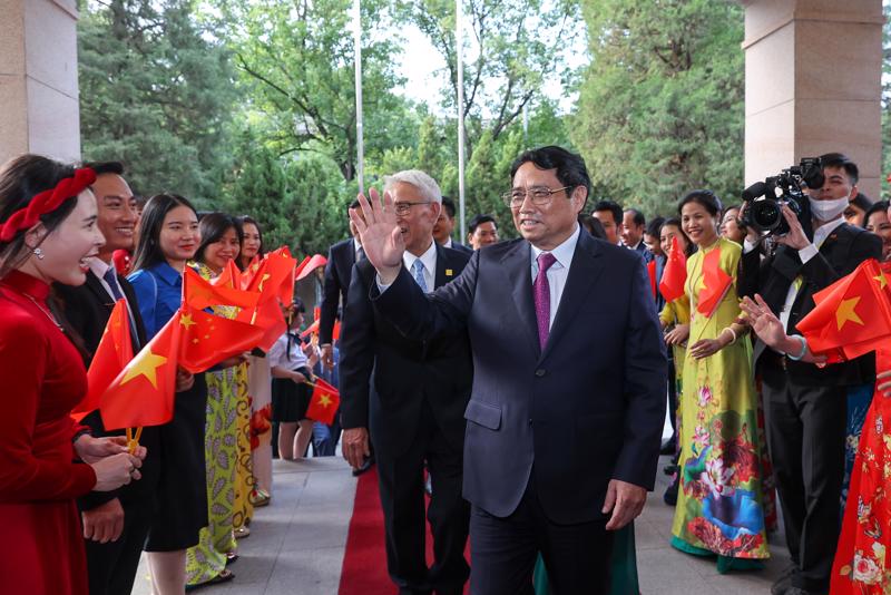 Đại diện kiều bào vui mừng đón Thủ tướng Phạm Minh Chính tới thăm chính thức Trung Quốc và dự Diễn đàn Kinh tế thế giới - Ảnh: VGP