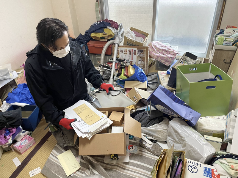 Nhân viên Công ty Bxia phân loại đồ đạc trong căn hộ của cụ bà 76 tuổi đã qua đời ở Tokyo - Ảnh: Japan Times.