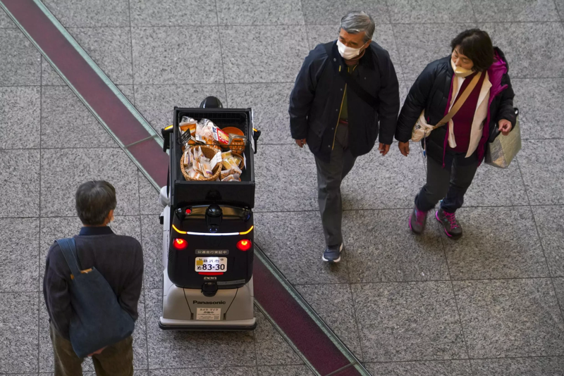 "Xin lỗi, cho đi qua!" - một robot giao hàng kêu lên khi tránh người đi bộ trên một con phố bên ngoài Tokyo. Ảnh: Samaaenglish