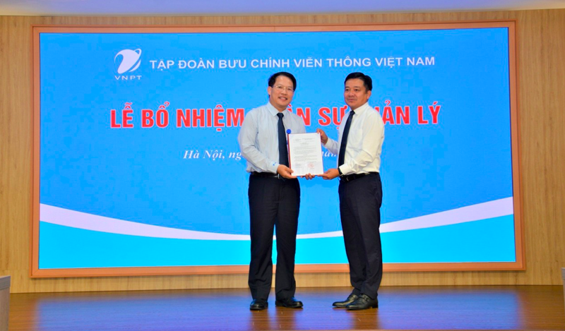 Ông Huỳnh Quang Liêm Tổng giám đốc Tập đoàn VNPT trao quyết định bổ nhiệm cho ông Nguyễn Văn Tấn (bên trái).