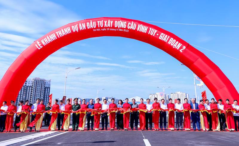 Prime Minister Pham Minh Chinh and delegates cut the ribbon to put Vinh Tuy Bridge 2 into operation. 