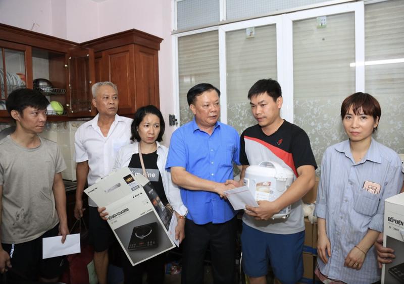 Bí thư Thành ủy Hà Nội Đinh Tiến Dũng trao quà hỗ trợ cho các nạn nhân vụ cháy chung cư mini tại phường Khương Đình. Ảnh: TTXVN