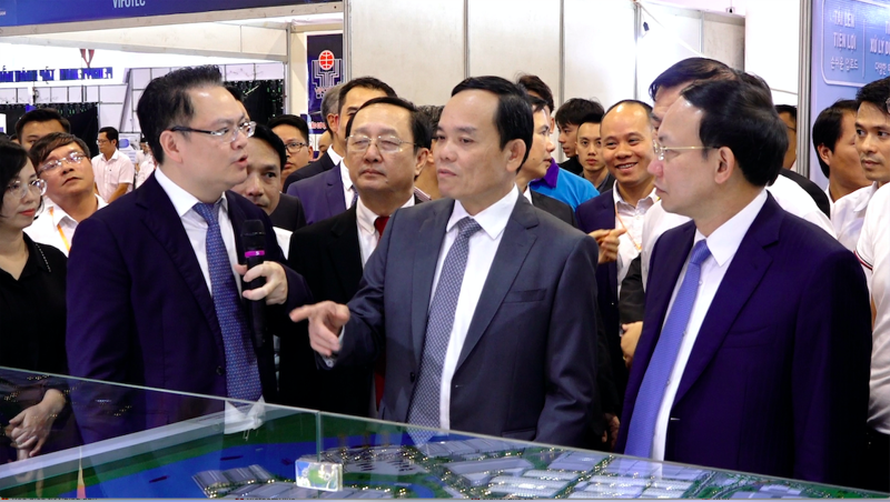 Deputy Prime Minister Tran Luu Quang and delegates visit a booth showcasing technological products.