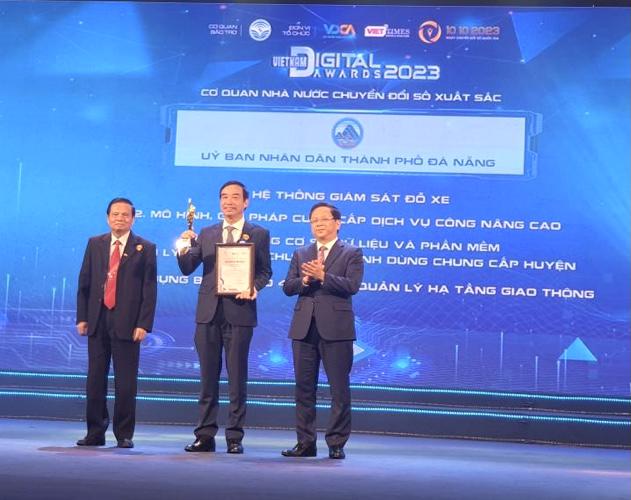 Chủ tịch UBND TP> Đà Nẵng (người đứng giữa) thay mặt lãnh đạo thành phố đón nhận Giải thưởng danh mục Cơ quan nhà nước Chuyển đổi số xuất sắc.
