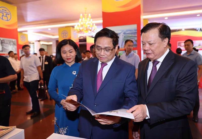 Prime Minister Pham Minh Chinh (2nd from right) visits a book exhibition held on the sidelines of the meeting. Photo: VNA