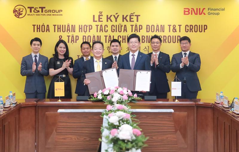 Ông Đỗ Quang Hiển, Chủ tịch UBCL Tập đoàn T&T Group (bên trái) và ông Bin Dae-in, Chủ tịch HĐQT kiêm Tổng giám đốc Tập đoàn Tài chính BNK (bên phải) trao thỏa thuận hợp tác với sự chứng kiến của đại diện lãnh đạo hai Tập đoàn.