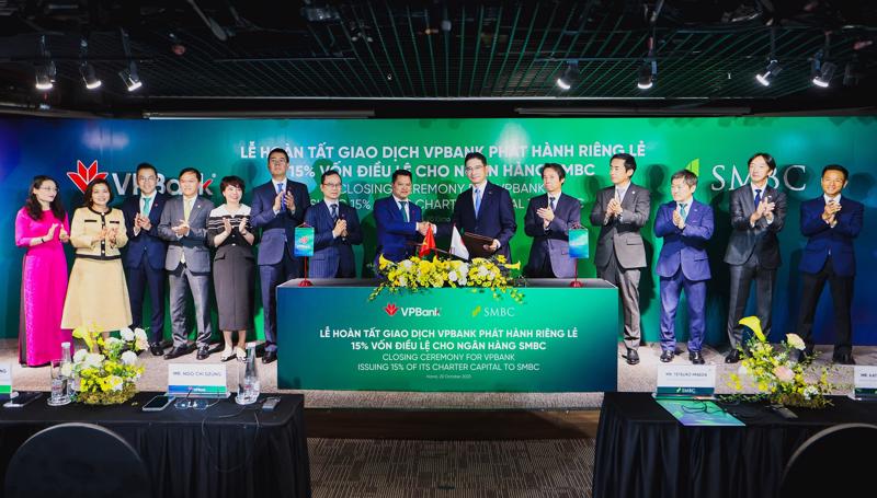 Representatives from the two banks exchange documents certifying the completion of the private placement.