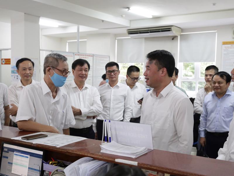 Tổng Giám đốc Bảo hiểm xã hội Việt Nam trao đổi với người dân đến làm thủ tục tại Bảo hiểm xã hội TP.HCM. Ảnh - BHXH Việt Nam.