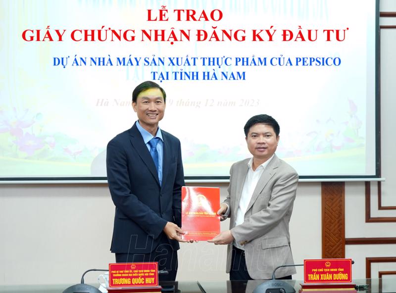 Mr. Truong Quoc Huy, Chairman of the Ha Nam Provincial People’s Committee (right), presents an investment certificate to a representative from PepsiCo Foods Vietnam. Source: Ha Nam Province Portal