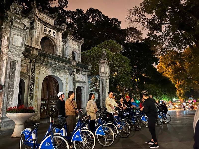 Tourists taking a night cycling tour of Hanoi.