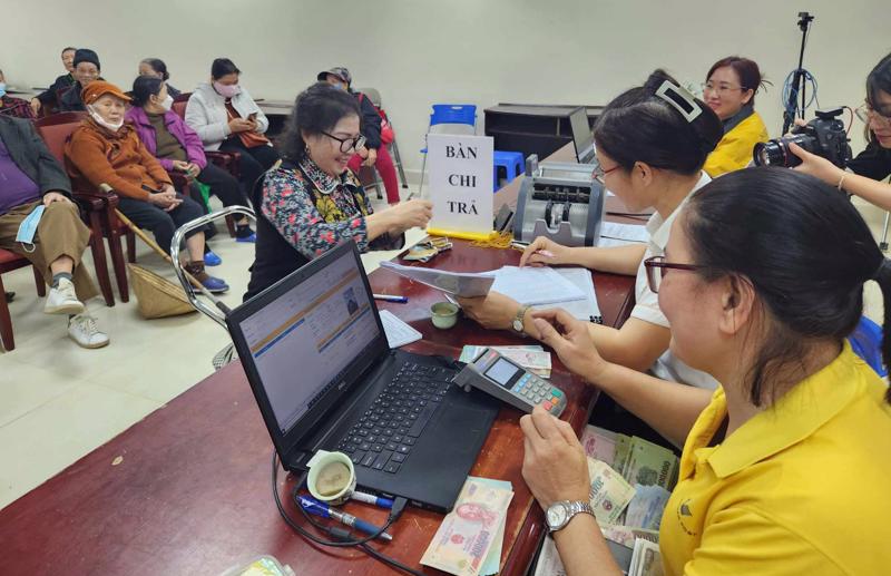 Chi trả lương hưu, trợ cấp bảo hiểm xã hội cho người hưởng tại Hà Nội ngày 5/1. Ảnh - Thu Hiền.