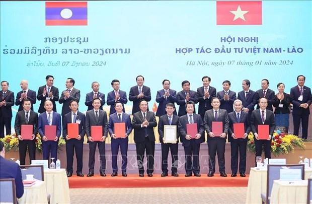 Vietnamese and Lao PMs witness the exchange of cooperation agreements between the two countries. (Photo: VNA)