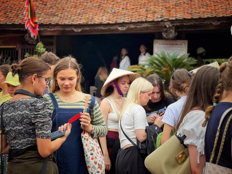 Foreign visitors experiencing the beauty of the ancient village of Duong Lam. (Source: VNA)
