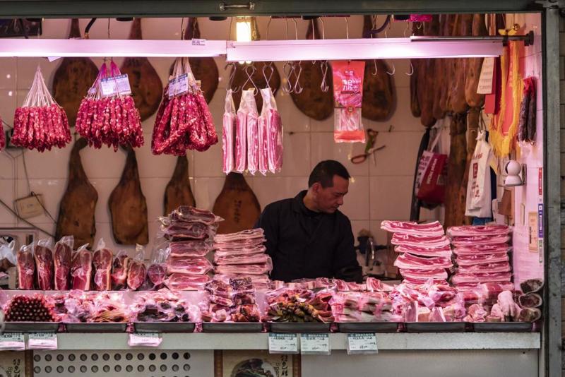 Tiểu thương buôn thịt lợn ở Trung Quốc lao đao vì nhu cầu tiêu thụ yếu dù Tết đã cận kề - Ảnh: Bloomberg